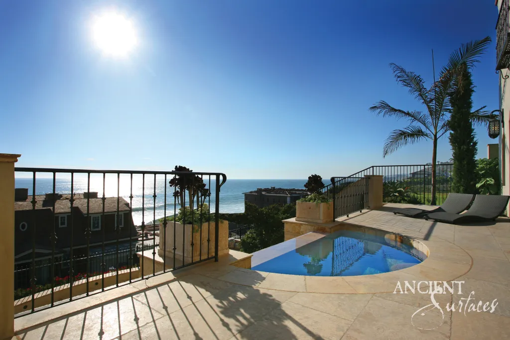 Reclaimed antique limestone terrace overlooking the Pacific at a coastal villa