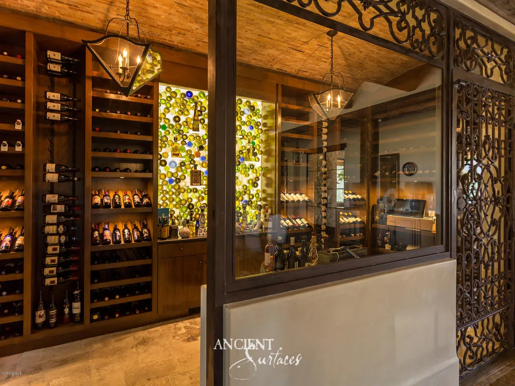 Reclaimed limestone wine cellar with wrought-iron grilles and antique stone flooring