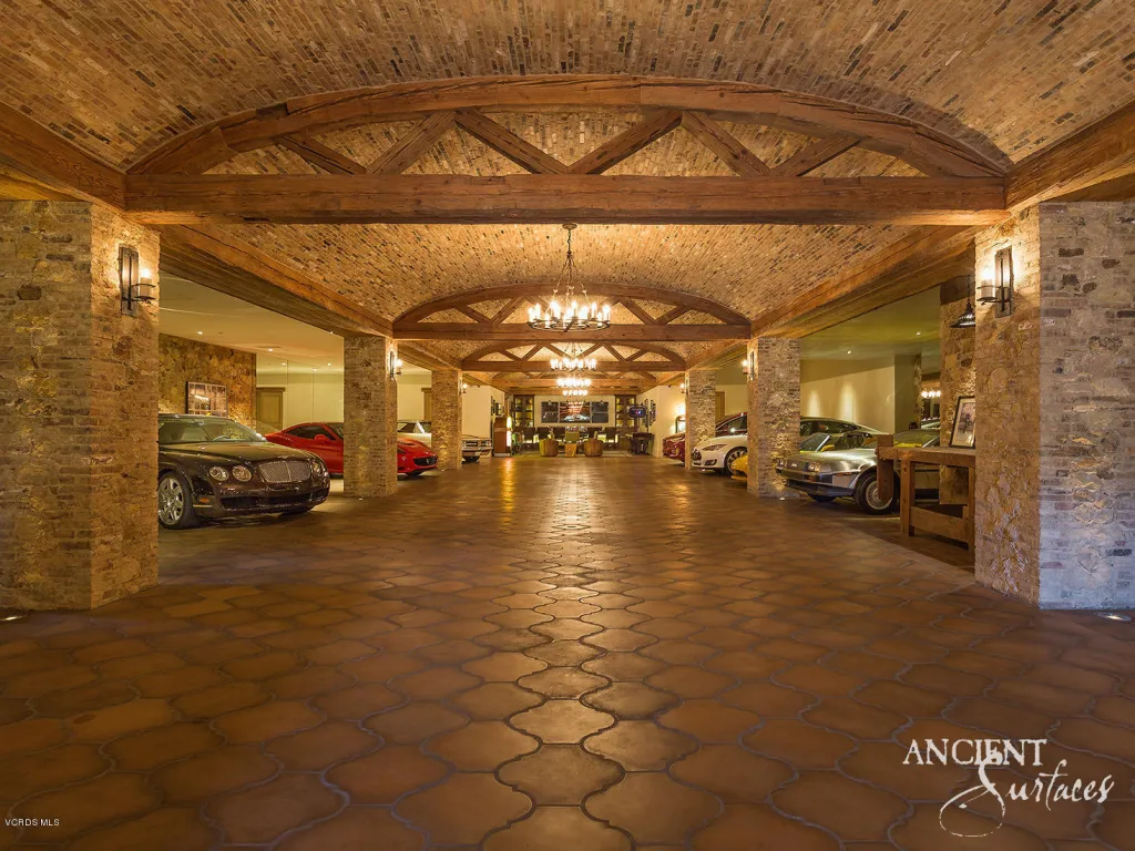 Vaulted brick motor gallery with antique terracotta floors and reclaimed stone columns