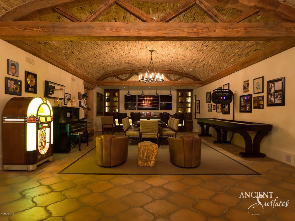 Entertainment room beneath a reclaimed brick barrel-vaulted ceiling with terracotta stone floors